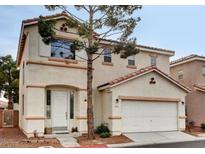 Two-story home with a two car garage, red tile roof, and desert landscaping at 971 Whispering Grove Ave, Las Vegas, NV 89123