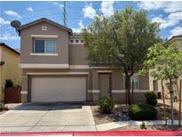 Inviting two-story home featuring an attached two-car garage and desert landscaping at 125 Sharp Edge Ave, North Las Vegas, NV 89031