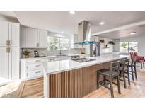 Bright kitchen featuring white cabinets, a large island with bar seating, and stainless steel appliances at 1731 Sherwin Ln, Las Vegas, NV 89156