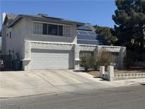 Two-story home featuring solar panels and a two-car garage with decorative window and block-wall front yard at 3061 Brockington Dr, Las Vegas, NV 89120