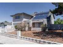 Two-story home featuring stucco exterior, solar panels, and a well-maintained front yard at 3061 Brockington Dr, Las Vegas, NV 89120
