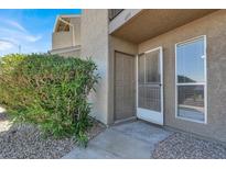 A tan two-story condo with gravel landscaping and a small decorative bush at the front door entrance at 433 Sellers Pl, Henderson, NV 89011