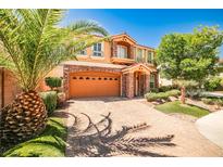 Two-story home featuring manicured landscaping and a brick-paved driveway leading to a spacious two-car garage at 6409 Shawnee Springs Ct, Las Vegas, NV 89139