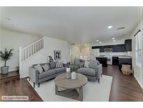 Bright living room featuring modern decor, hardwood floors, and a staircase, creating an inviting atmosphere at 6485 Arrow Cottage Ct, Las Vegas, NV 89130