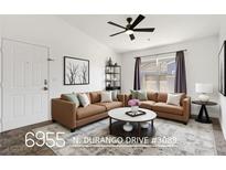 Bright living room features neutral tones, modern furnishings, and a stylish ceiling fan at 6955 N Durango Dr # 3089, Las Vegas, NV 89149