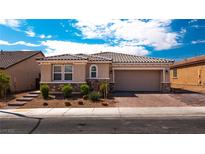 Inviting single-story home with stone accents, lush landscaping, and a two-car garage at 7525 Campbell Ranch Ave, Las Vegas, NV 89179