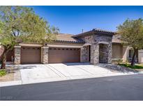 Charming single-story home with a stone facade, three-car garage, and a well-manicured front yard at 8544 Garden Valley Ct, Las Vegas, NV 89178
