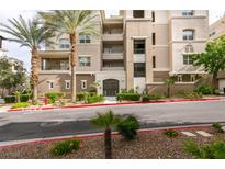 Beautiful condo building featuring manicured landscaping and mature palm trees at 9201 Tesoras Dr # 302, Las Vegas, NV 89144