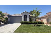 Charming single-story home with a well-manicured lawn, mature landscaping, and a gray exterior at 988 Upper Meadows Pl, Henderson, NV 89052