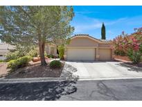 Charming single-story home featuring a three car garage and mature landscaping at 10805 Hollow Creek Ln, Las Vegas, NV 89144