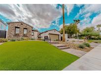 Charming single-story home featuring a well-manicured artificial lawn and stone accents at 11477 Timber Mountain Ave, Las Vegas, NV 89135