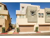 Modern townhome exterior with individual garages, desert landscaping and neutral color palette at 1275 Ice Park St # 101, Las Vegas, NV 89135