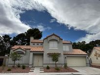 Charming two-story home featuring a stucco exterior, red tile roof, and a well-manicured front yard at 3005 Treasure Island Rd, Las Vegas, NV 89128