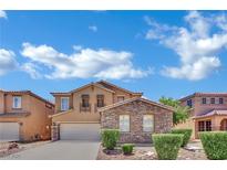 Charming two-story home featuring a stone facade, balcony, manicured landscaping, and a two-car garage at 3217 Bonassola Ave, North Las Vegas, NV 89031