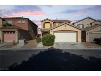 Inviting two-story home featuring a two-car garage, desert landscaping, and a cozy front entryway at 5573 La Perla Ct, Las Vegas, NV 89122