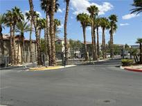 View of the gated community entrance featuring lush palm trees and well-maintained landscaping at 8000 Badura Ave # 1168, Las Vegas, NV 89113