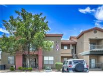 Inviting exterior showcasing well-maintained condo building, lush tree, and convenient parking at 8000 Badura Ave # 1168, Las Vegas, NV 89113