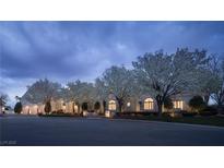 Stunning twilight view of estate with lush landscaping and flowering trees at 1610 Brock Ct, Las Vegas, NV 89117