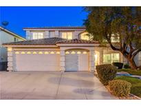 Two story home featuring a three-car garage, tile roof, and manicured lawn with mature tree at 1721 Sweet Pea Ave, Las Vegas, NV 89183