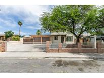 Charming single-story home featuring a two-car garage, gated entry, and mature tree at 1806 Renada Cir, North Las Vegas, NV 89030