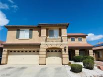 Inviting two-story home featuring a three-car garage and well-maintained front yard landscaping at 1904 Imola Ct, Las Vegas, NV 89123