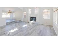 Open living room featuring a fireplace and light gray vinyl floors at 1904 Imola Ct, Las Vegas, NV 89123