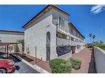Attractive condo building with tan stucco exterior, red rock landscaping and covered parking at 2080 Karen Ave # 12, Las Vegas, NV 89169