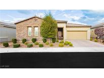 Charming single-story home with stone accents, a two-car garage, and a well-manicured front yard at 2450 Amatrice St, Henderson, NV 89044
