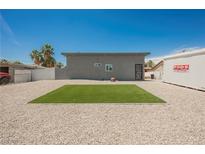 View of the home's backyard featuring gravel, a patch of grass, and a PODS moving container at 2807 Hermosa St, Las Vegas, NV 89169