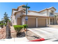 Inviting two-story home featuring a two-car garage, tiled roof, and neat landscaping for great curb appeal at 7553 Durham Hall Ave # 201, Las Vegas, NV 89130