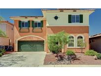 Charming two-story home showcasing a green garage door, shutters and lush landscaping at 7920 Aviano Pines Ave, Las Vegas, NV 89129
