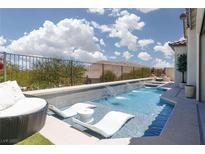 Relaxing pool with two lounge chairs and waterfall feature, perfect for enjoying sunny days at 12844 New Providence St, Las Vegas, NV 89141