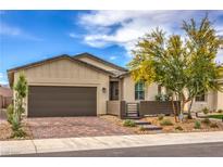 Charming single-story home with a two-car garage, desert landscaping, and a brick driveway and walkway at 2114 Thelen Ave, North Las Vegas, NV 89086