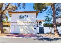 Two-story stucco home featuring a garage and private gated entrance at 2204 Plaza De La Candela, Las Vegas, NV 89102
