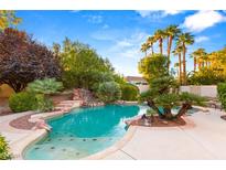 Backyard pool featuring mature landscaping, including palm trees and a rock waterfall at 4649 Bird View Ct, Las Vegas, NV 89129