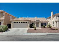 Charming single-story home with a tile roof, desert landscaping, and an attached two-car garage at 472 Staghorn Pass Ave, Las Vegas, NV 89183
