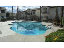 Community pool surrounded by well-maintained landscaping and nearby buildings at 4821 Black Bear Rd # 104, Las Vegas, NV 89149