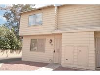 Beige two-story townhome with decorative front door and grated window at 5086 Mountain Vista St, Las Vegas, NV 89120