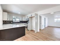 Bright eat-in kitchen with shaker cabinets, dark tile backsplash, quartz counters and stainless appliances at 6308 Lawton Ave, Las Vegas, NV 89107