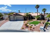 Charming single-story home with a three car garage, desert landscaping and palm trees under a blue sky at 7540 Crystal Cave Dr, Las Vegas, NV 89117
