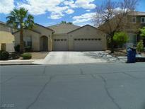 Charming single-story home with a two-car garage, desert landscaping, and a palm tree at 981 Buffalo River Ave, Henderson, NV 89002