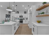 Modern kitchen features white cabinetry, stainless steel appliances and pendant lighting at 10801 Clarion Ln, Las Vegas, NV 89134