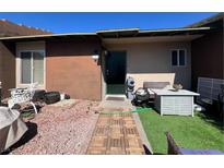 Inviting front entry featuring desert landscaping, stylish outdoor furniture, and a quaint, welcoming atmosphere at 111 E Van Wagenen St, Henderson, NV 89015