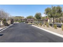 View of the community entrance with stone features and well-maintained landscaping at 12243 Pacific Cruise Ave, Las Vegas, NV 89138