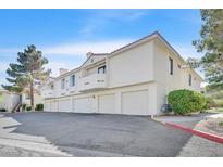 Low angle shot showing exterior of condo building with multiple garages, balconies, and red clay roof at 2633 S Durango Dr # 204, Las Vegas, NV 89117