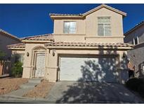 Two-story home featuring a two-car garage, desert landscaping, and a secured front entry gate at 2694 Rimpacific Cir, Las Vegas, NV 89146