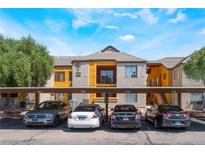 Apartment complex featuring covered parking, yellow exterior accents, and well-maintained landscaping at 2700 N Rainbow Blvd # 1080, Las Vegas, NV 89108
