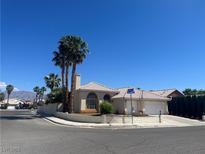 Charming stucco home features a tile roof, two-car garage, palm trees, and corner lot appeal at 3136 Jane Austin Ave, North Las Vegas, NV 89031