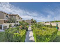 Landscaped walkway leading to a community with lush greenery and blue skies at 3253 Mystic Ridge Ct, Las Vegas, NV 89129
