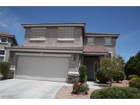 Two-story home featuring desert landscaping, a two-car garage, and a tile roof under a clear blue sky at 3440 Crystal Tower St, Las Vegas, NV 89129
